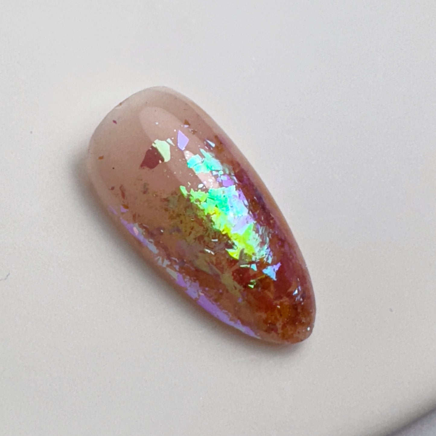 Decorated nail tip on white surface