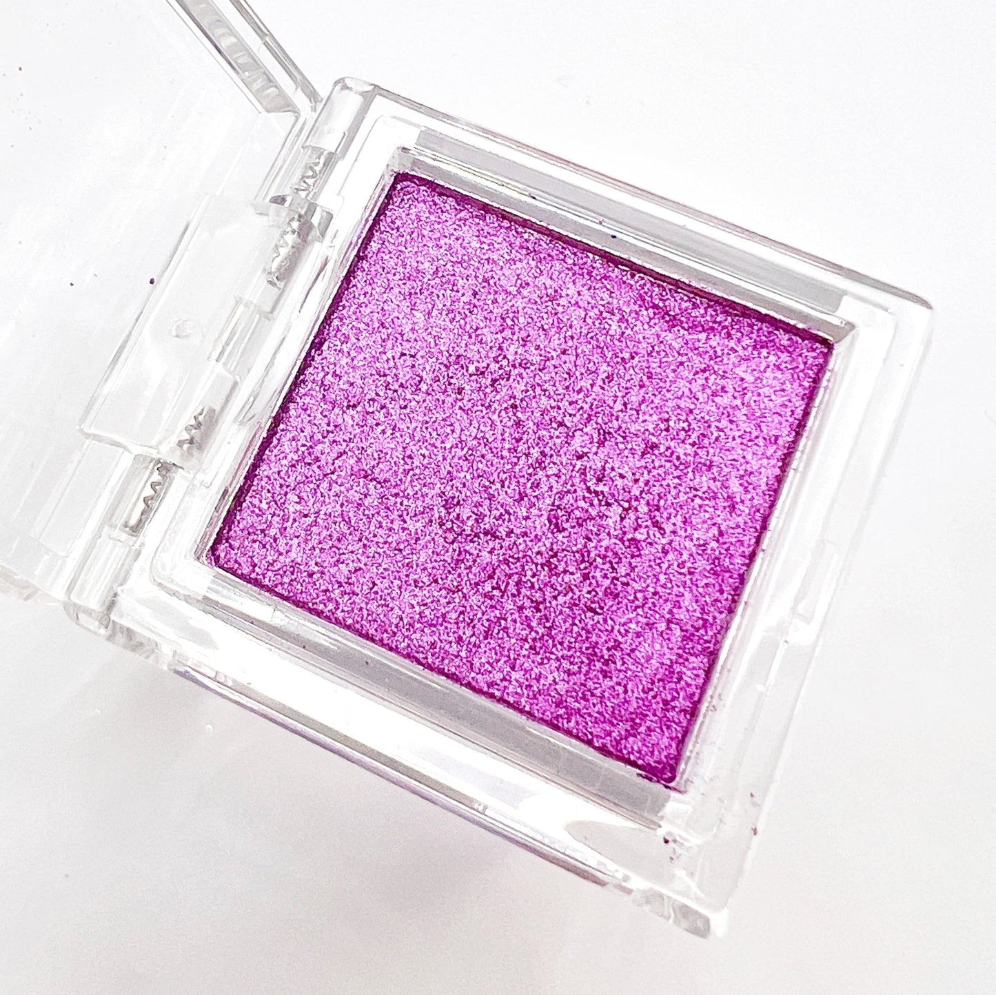 Detail view of compact with metallic powder on white background.
