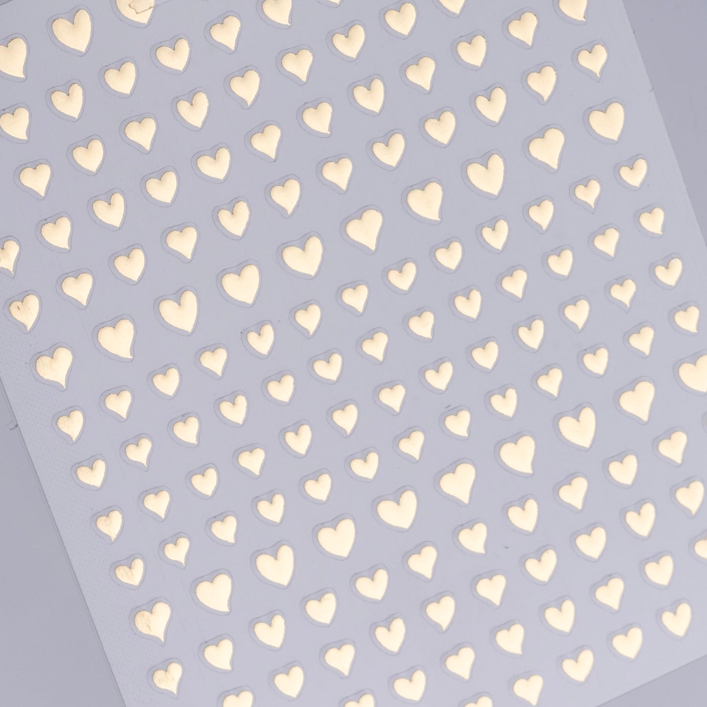 Pattern of gold hearts on a light purple background