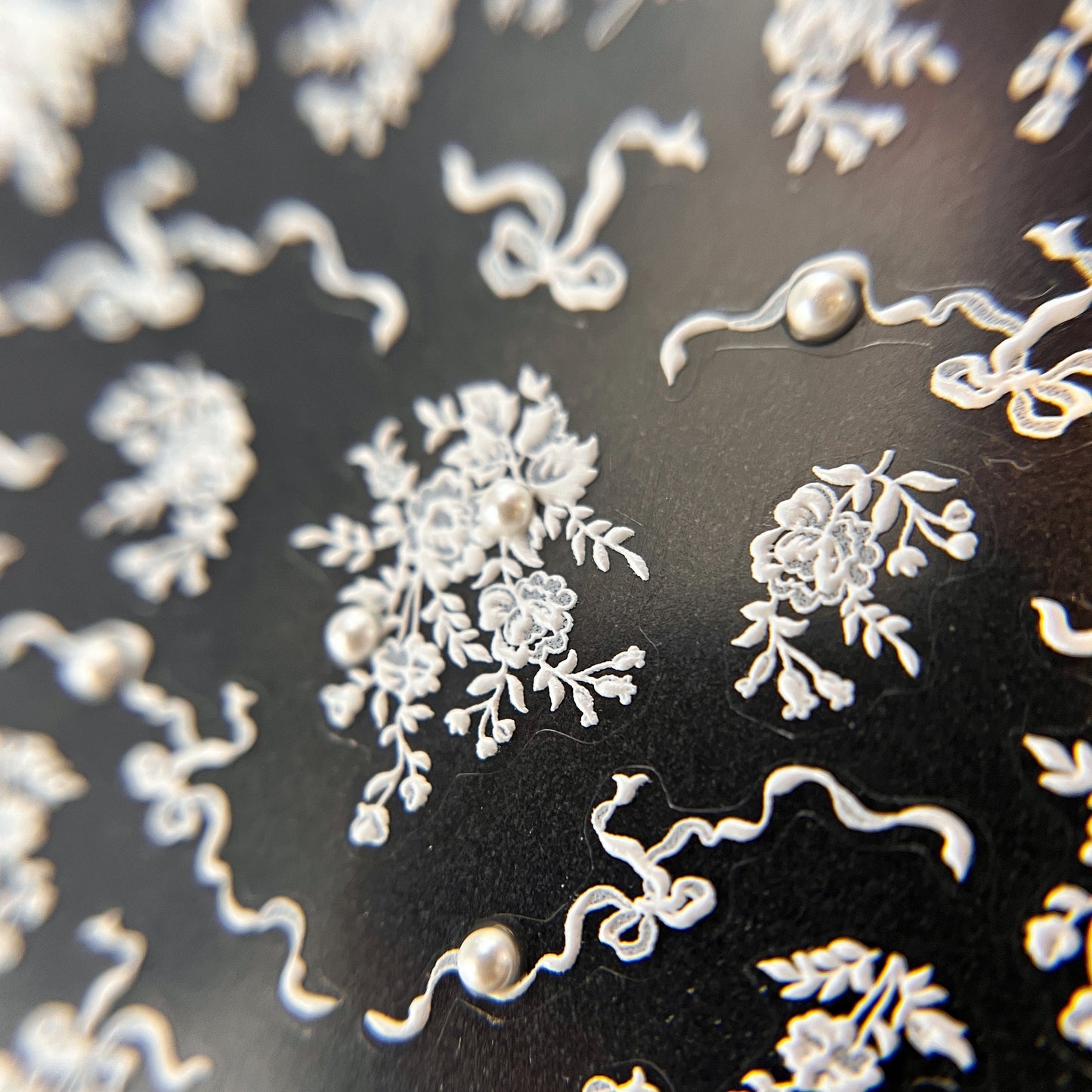 Lace and Pearl Nail Stickers in White - Raised Texture Lace Floral Design with 3D Pearl Detail, Displayed on Black Background.