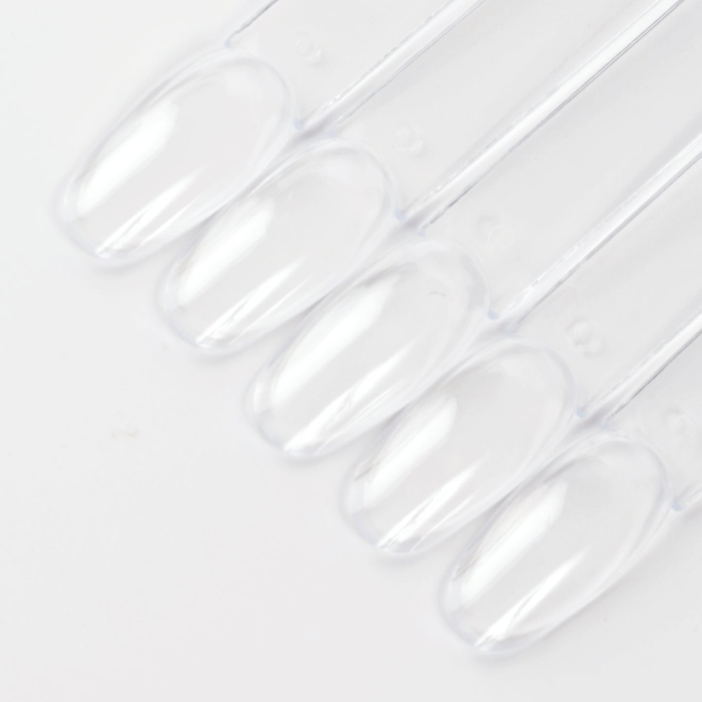 Clear oval nail swatch sticks on white background.