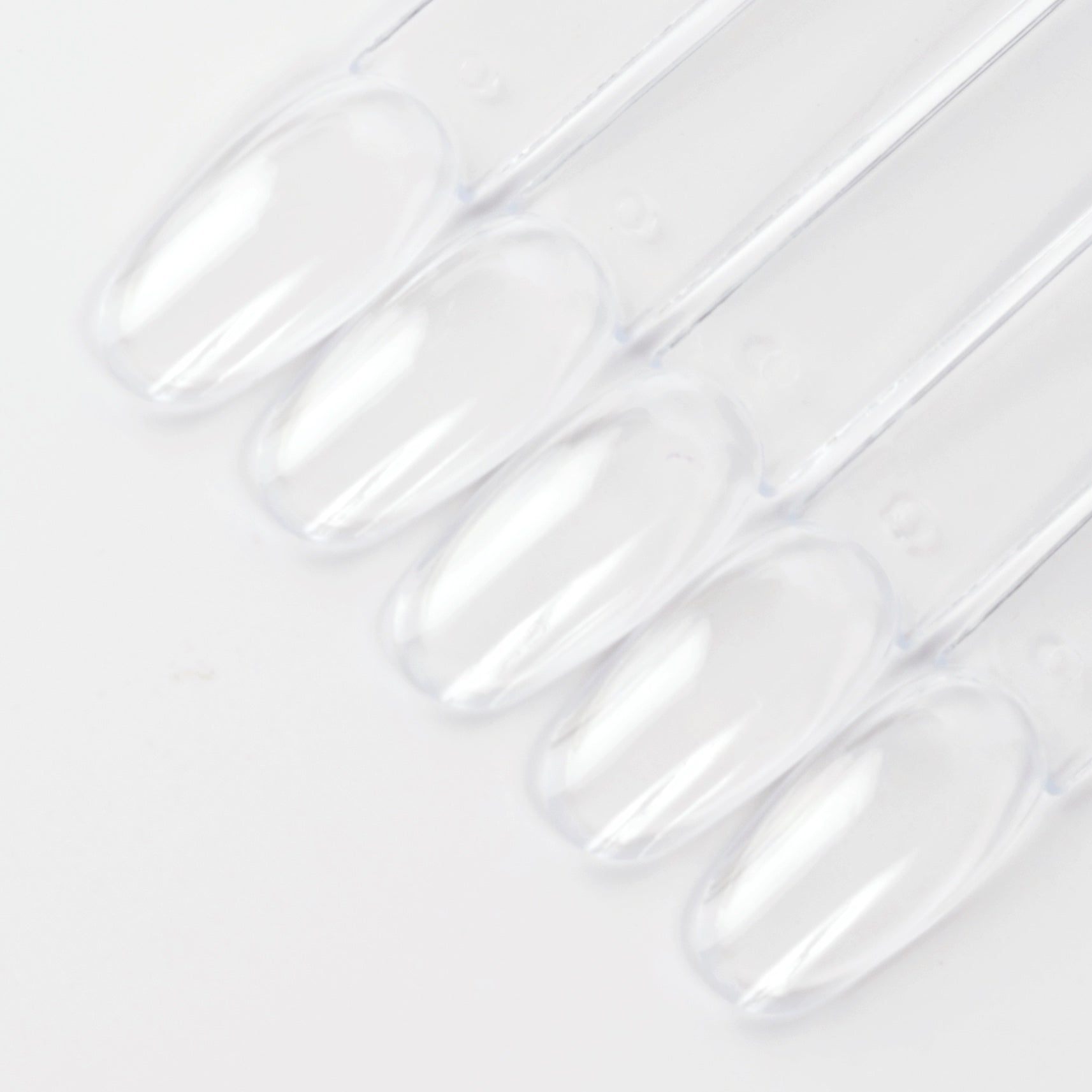 Clear oval nail swatch sticks on white background.