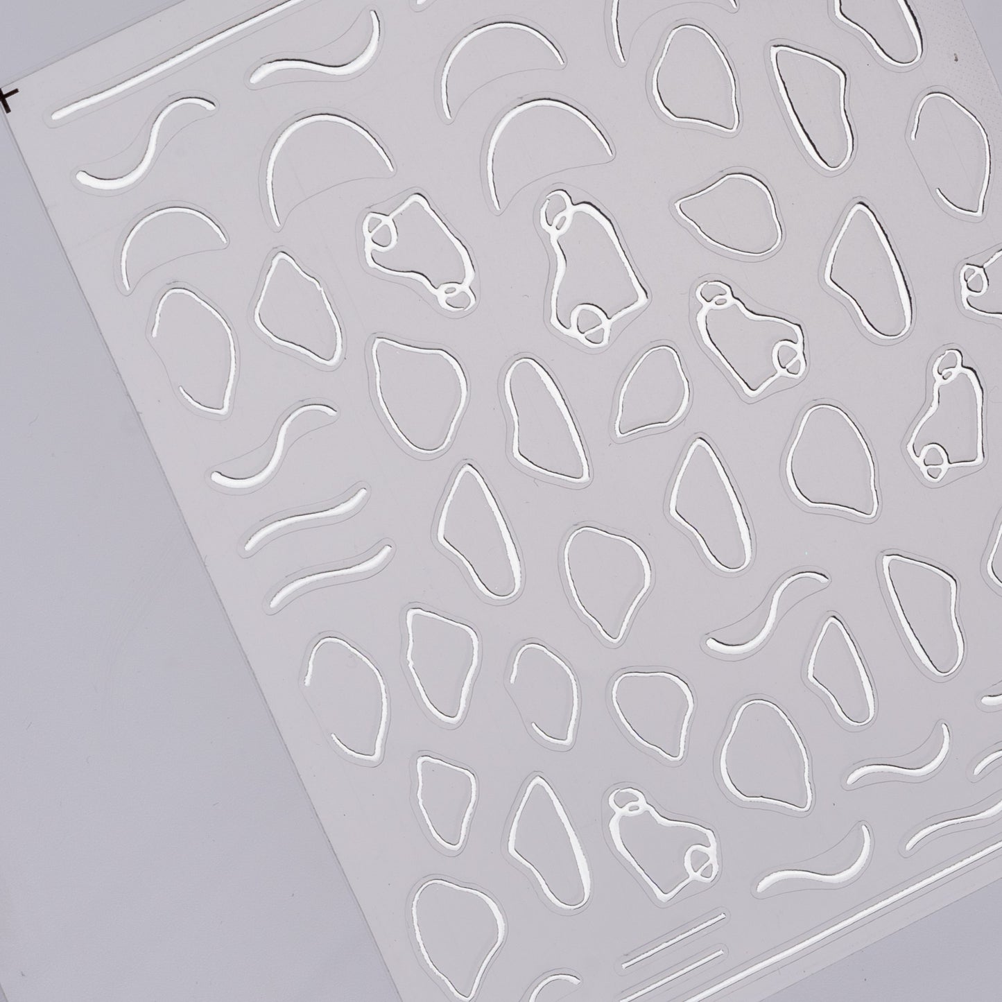 Photo of metallic abstract stickers with raised textue on white background.