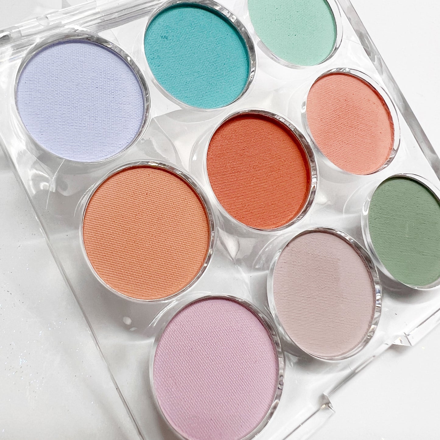Multicolor pigment palette in clear case on white background.