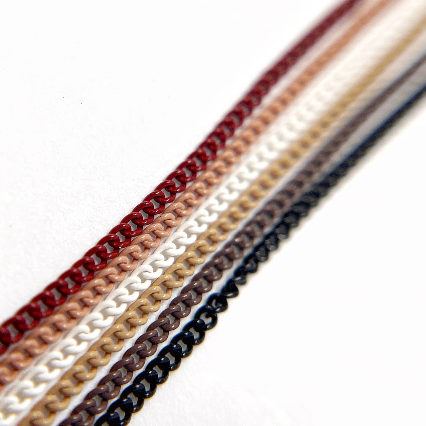 Close-Up of Multi-Color Nail Art Chains in neutral tones on White Background.