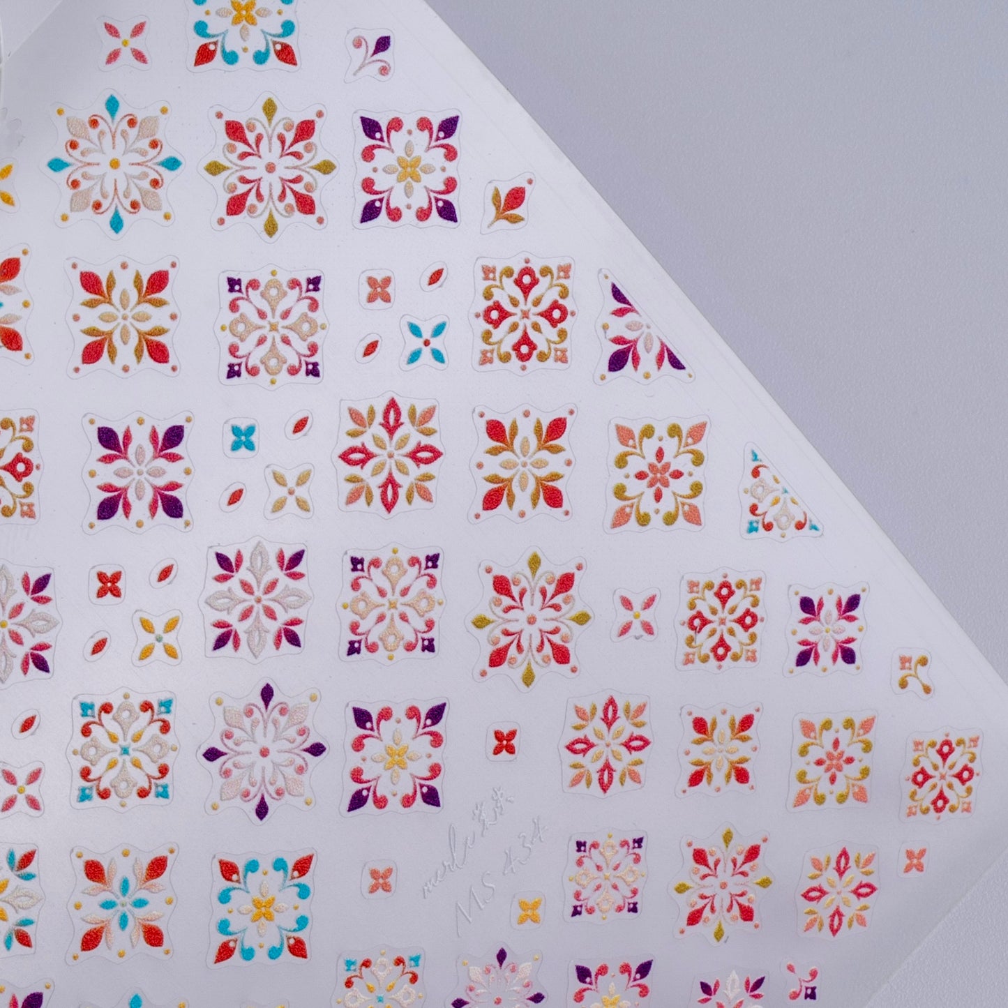 Detail view of nail decal sheet on light background.