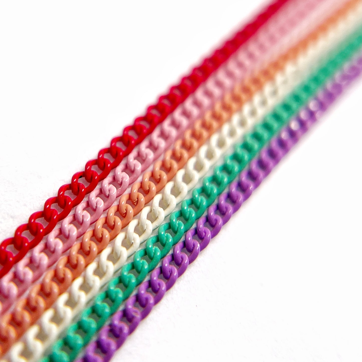 Close-Up of Multi-Color Nail Art Chains in vivid tones on White Background.