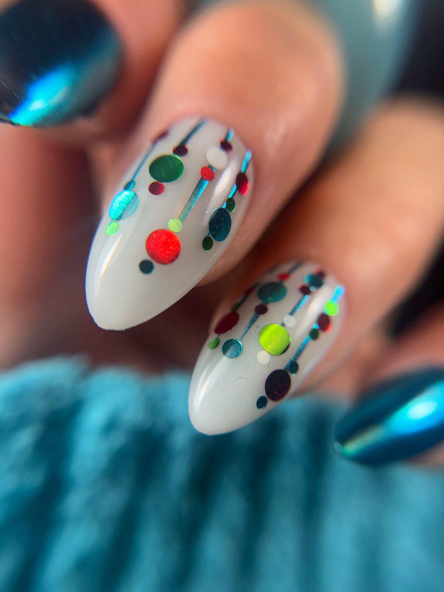 Close-up of nails with colorful polka dot design on a blurred background