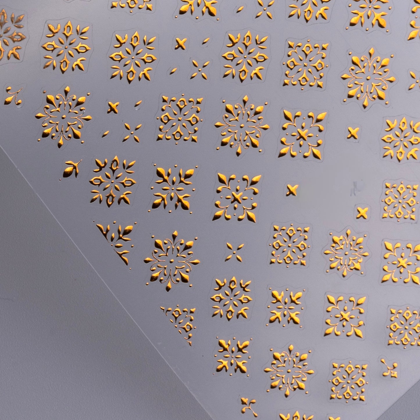 Metallic nail decal sheet on gray background.