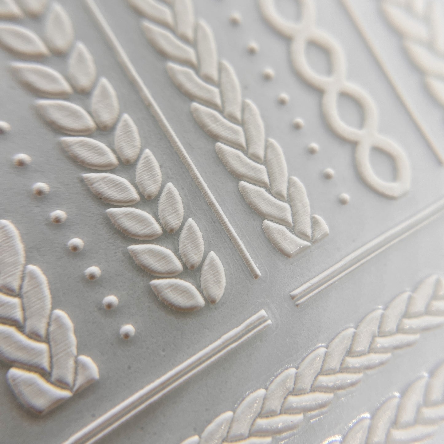 Detailed view of embossed texture white braided stickers.