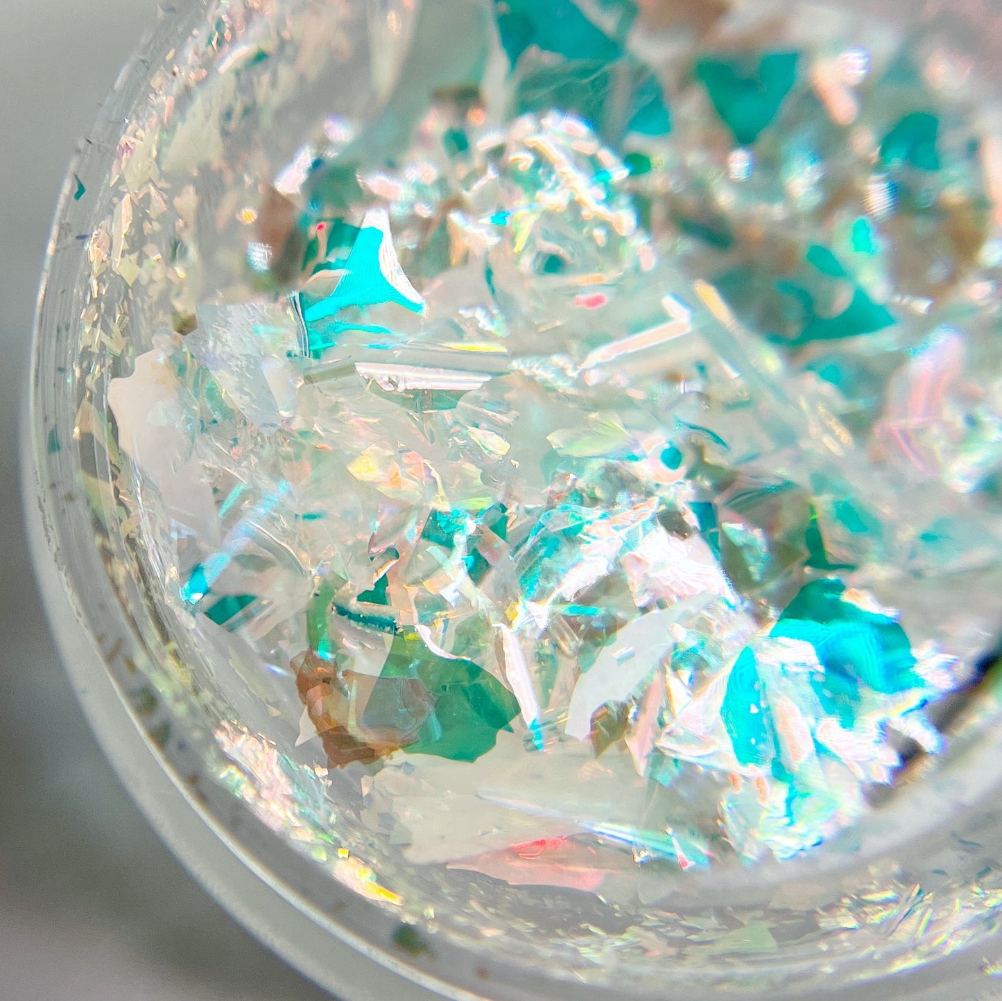 Detailed view of mutichromatic flakes on white background.