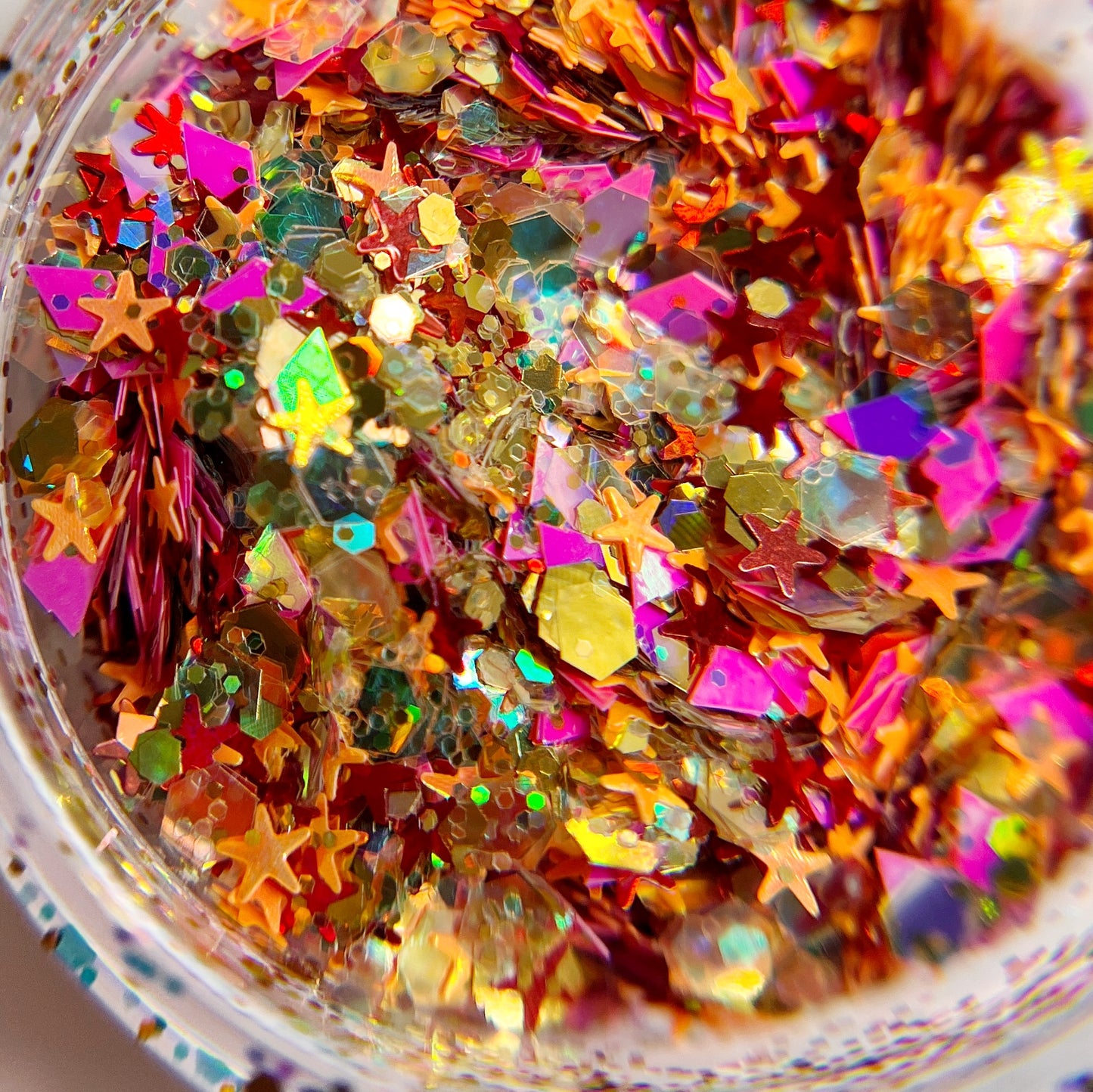 Detailed view of glitter in clear jar on white background.