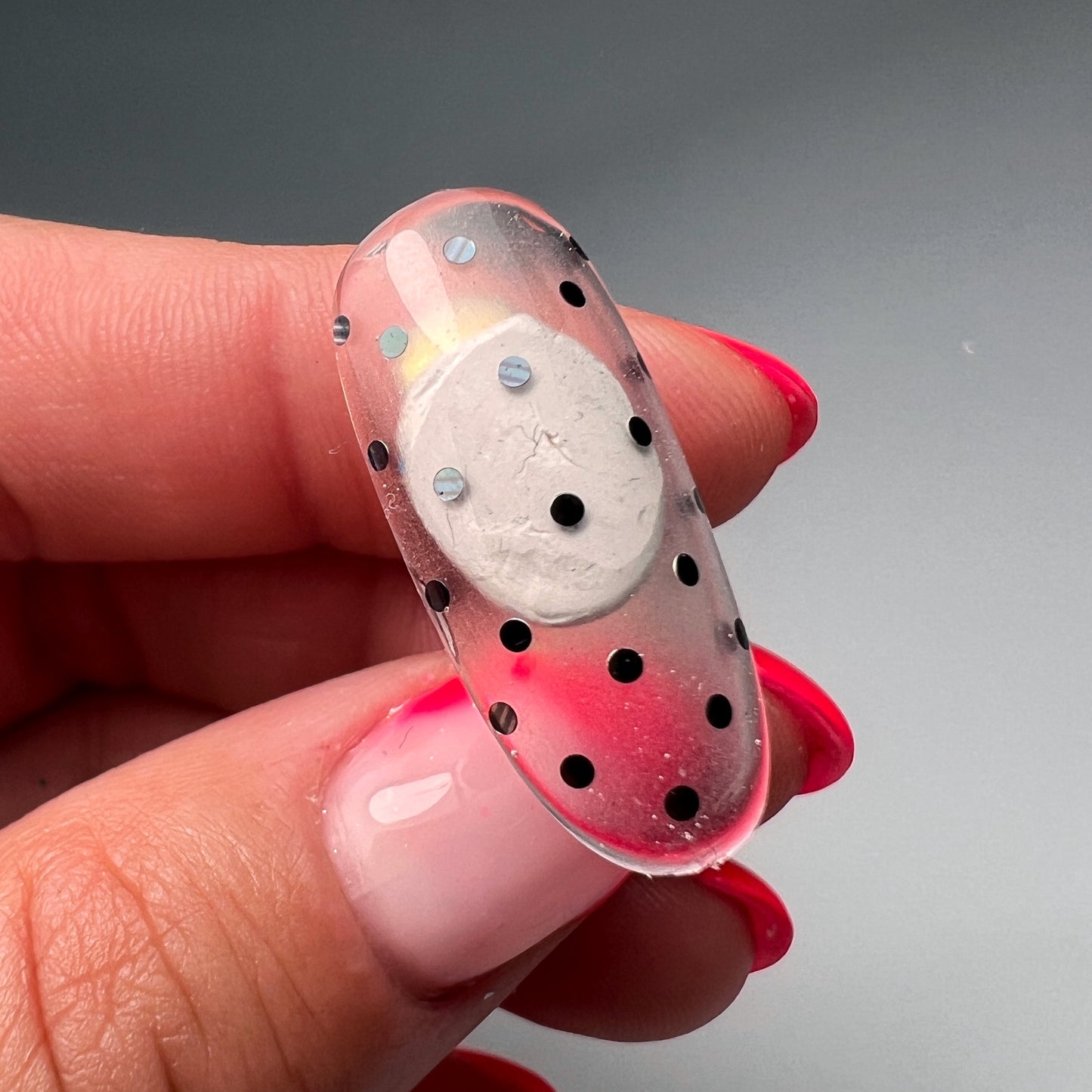 Hand holding decorated nail tip.