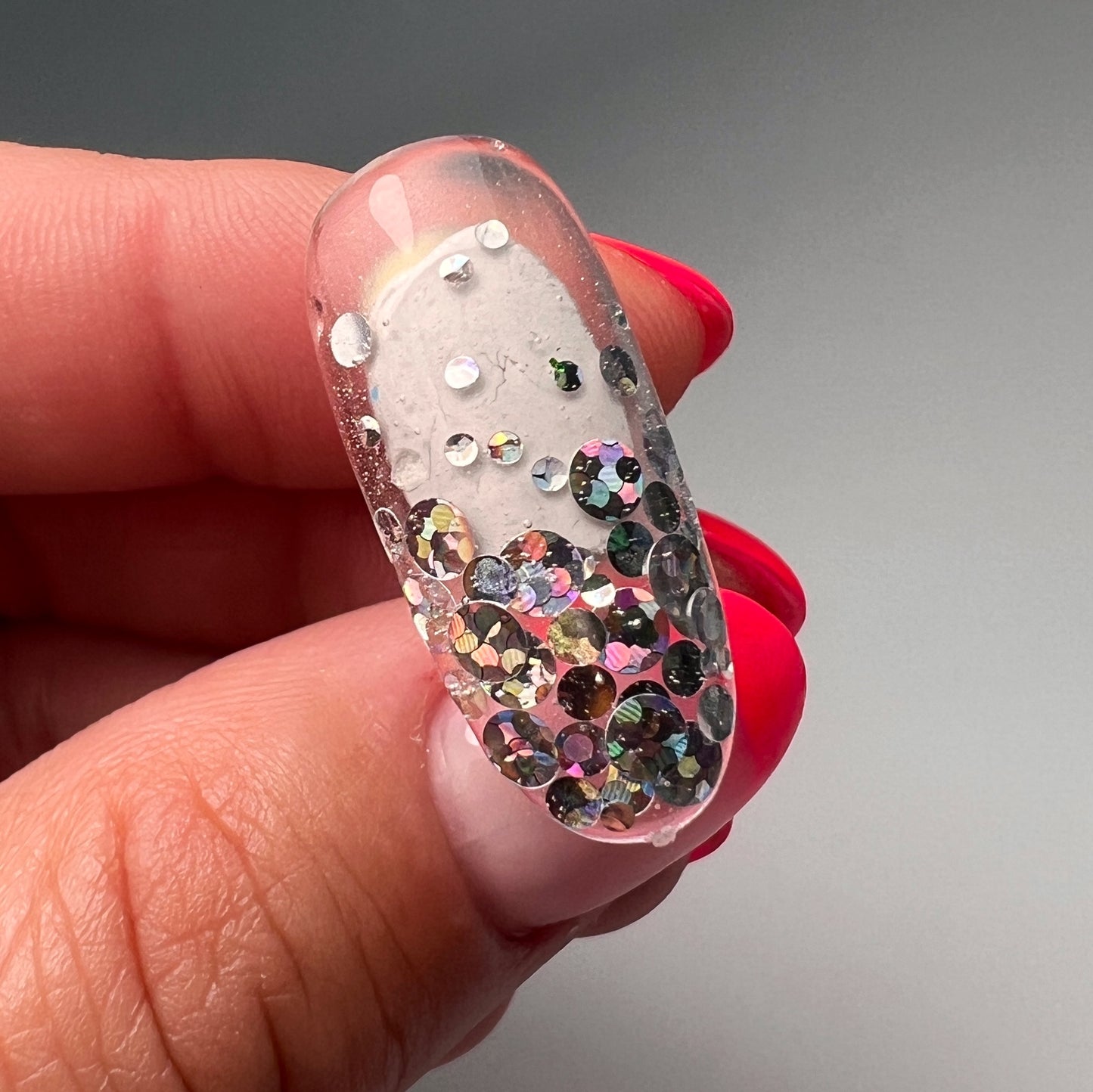 hand holding decorated nail tip.