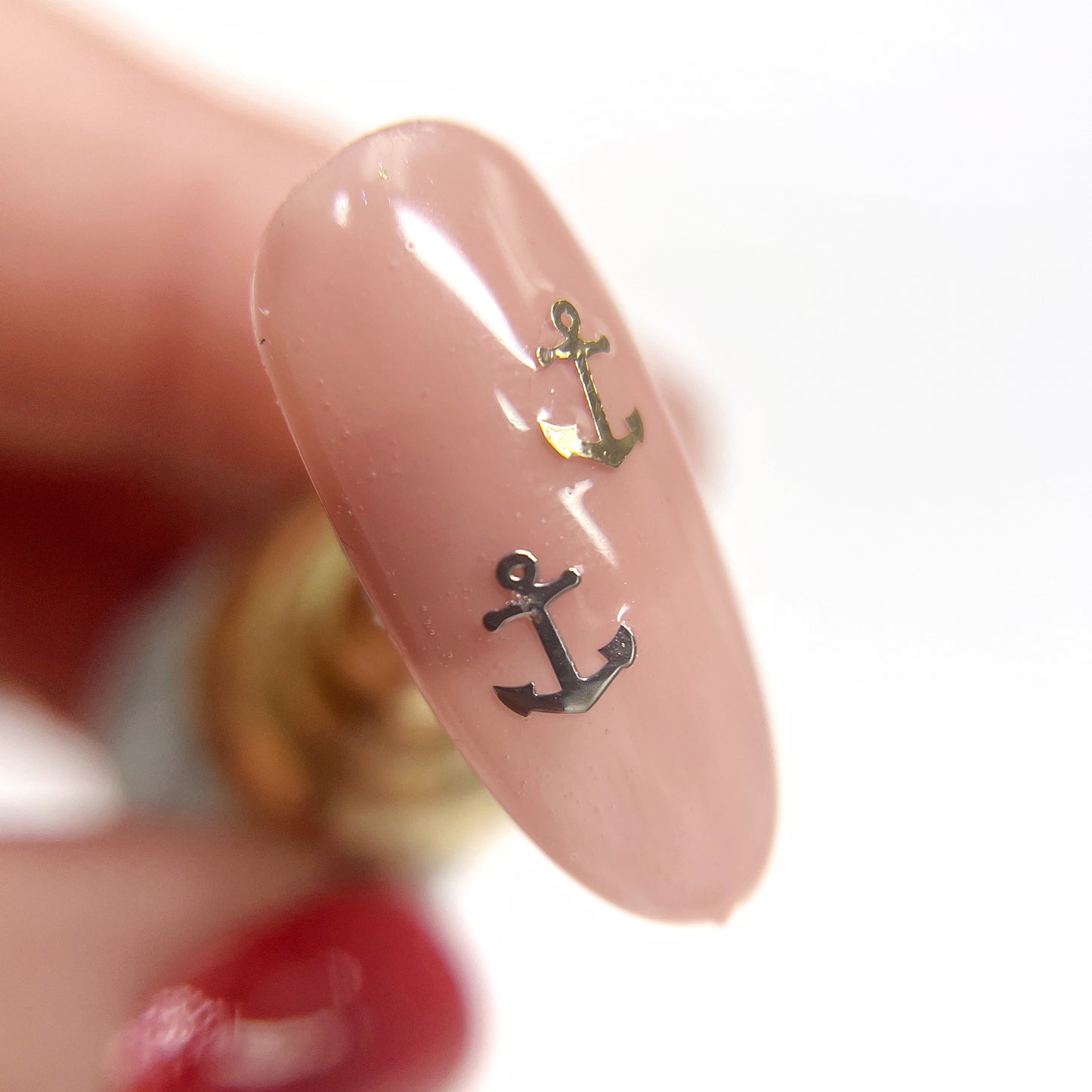 Hand holding a nail tip on white background.