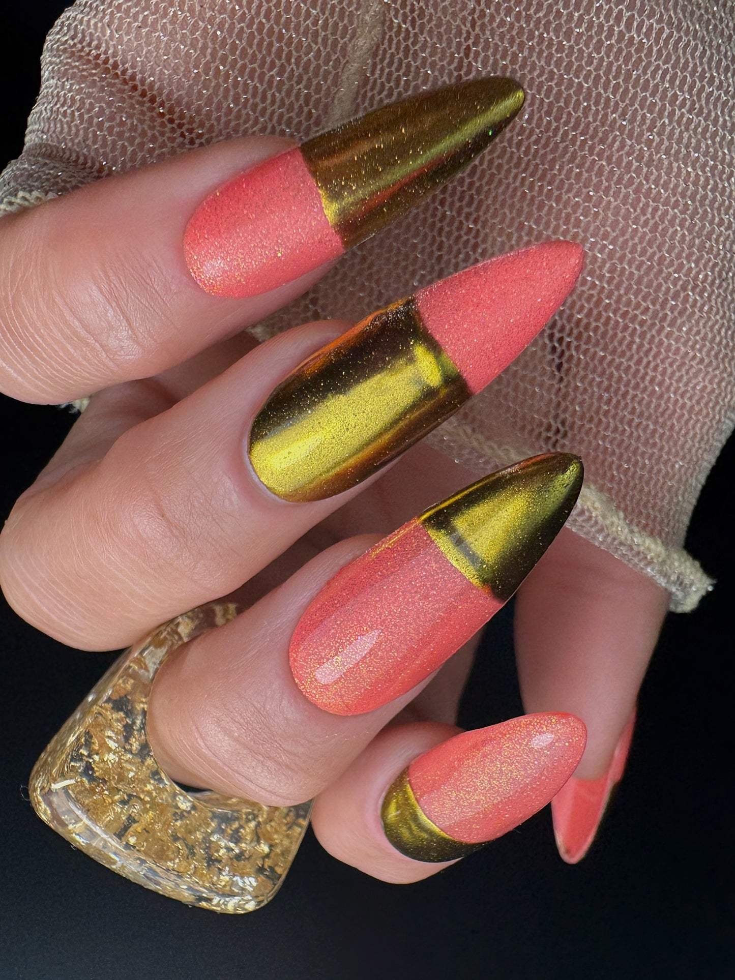 Nails with pink and gold design held by a hand