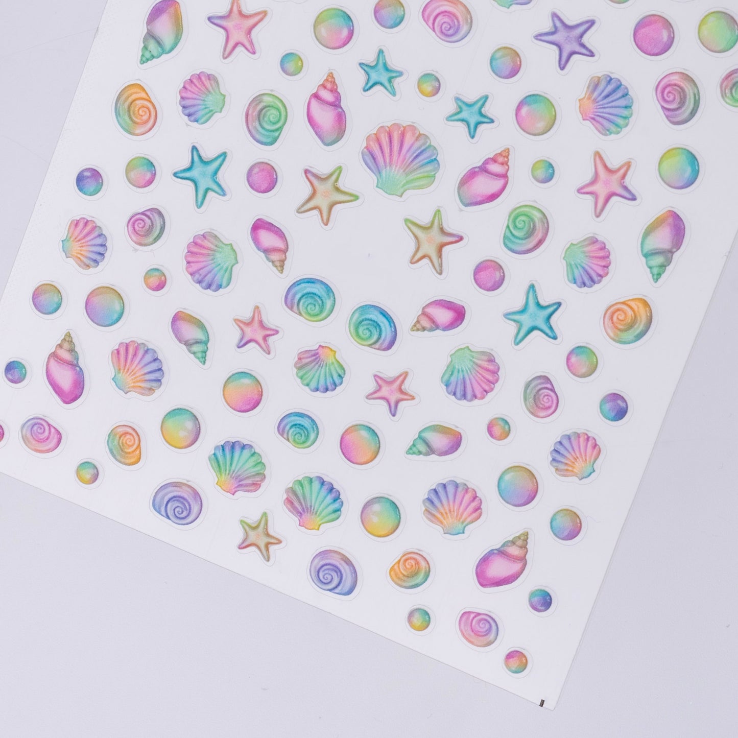 Sheet of colorful star, shell, and swirl stickers on a white background
