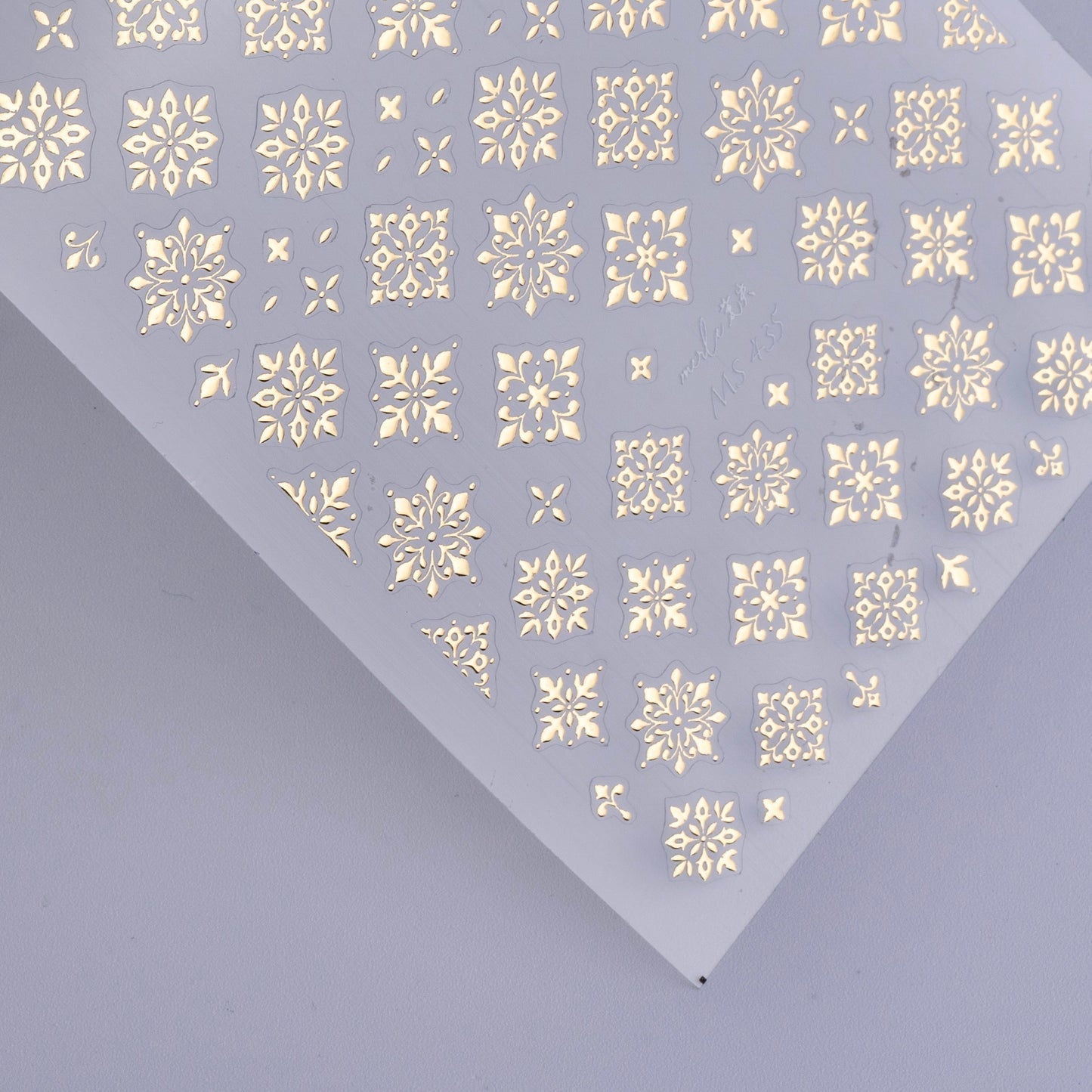 Detail view of nail decal sheet on light background.