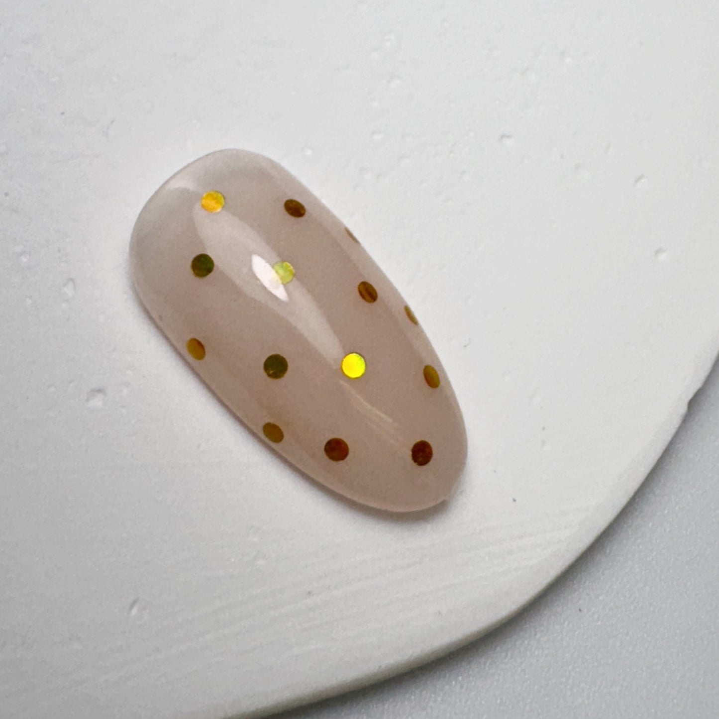 decorated nail tip on textured white surface