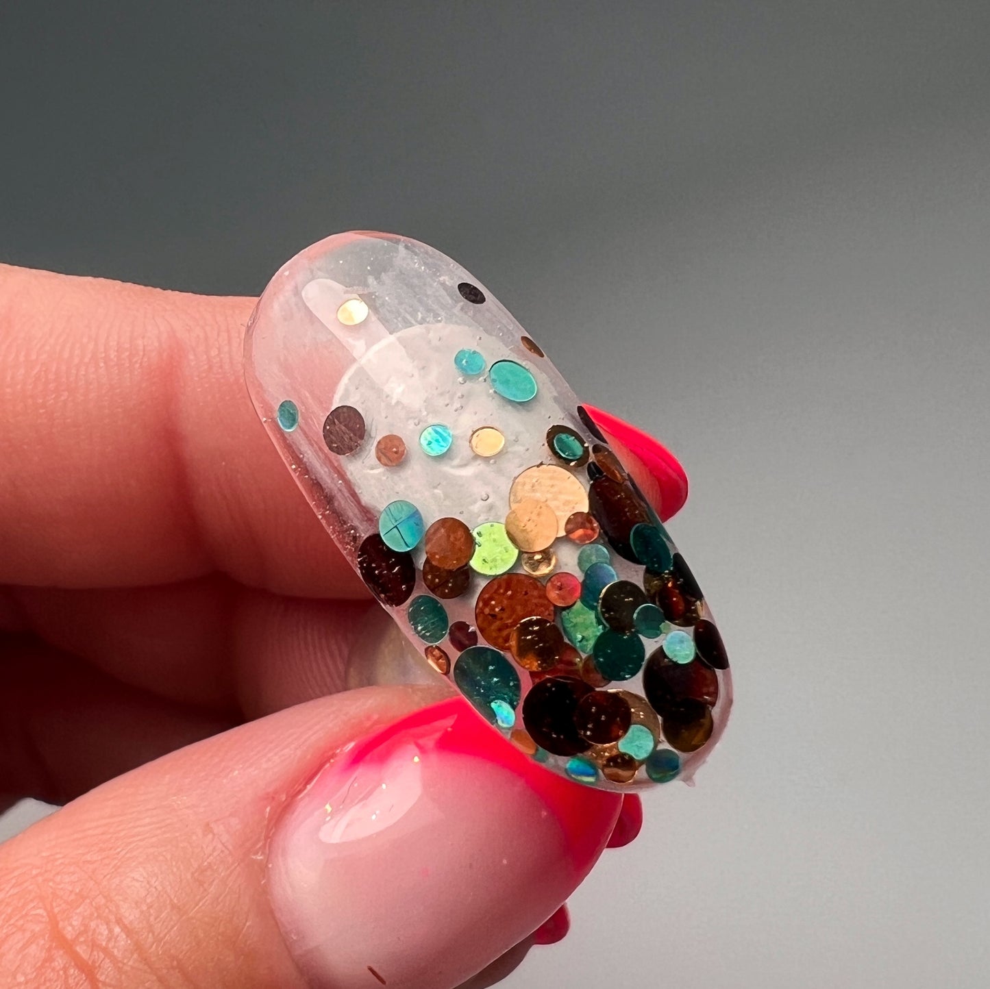 Hand holdig decorated nail tip.