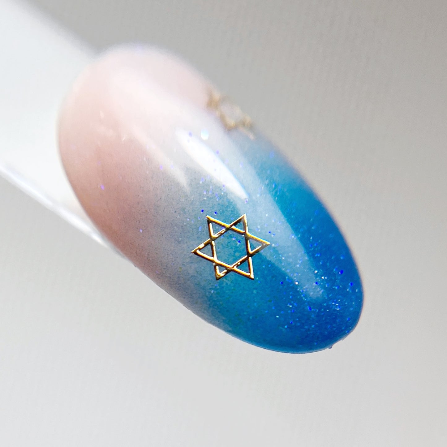 Nail art tips with blue ombre and star detail.