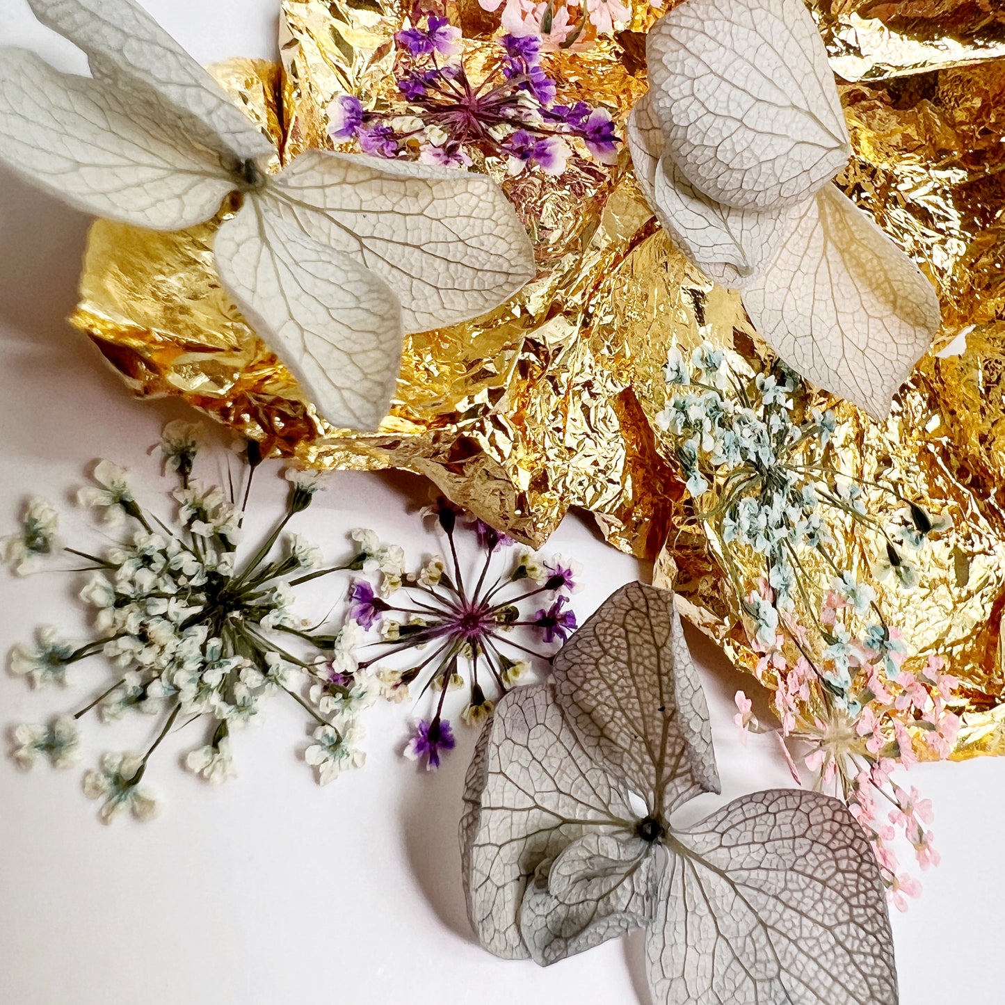 Floral and foil mix on white background.