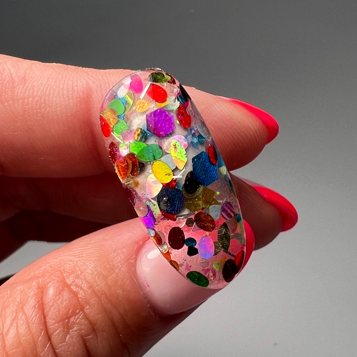 Hand holding decorated nail tip.