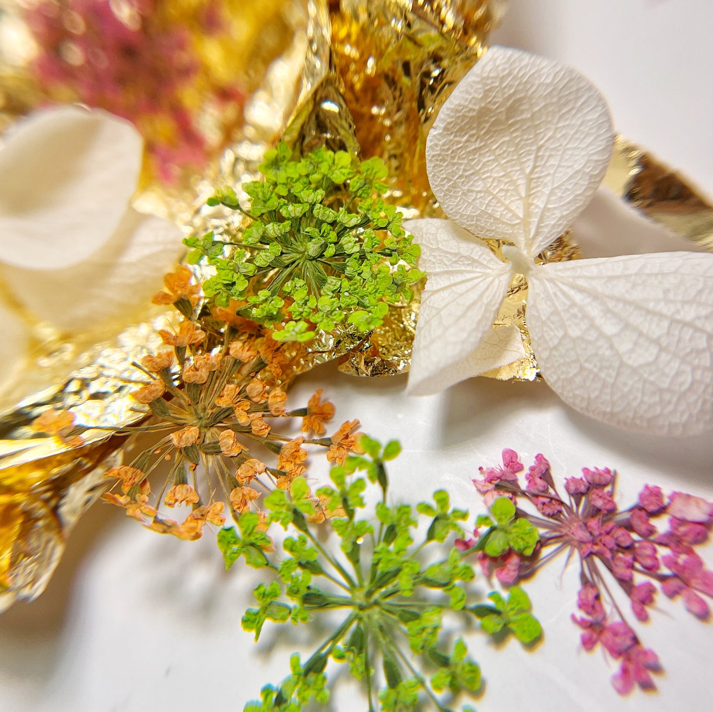 Floral and foil mix on white background.