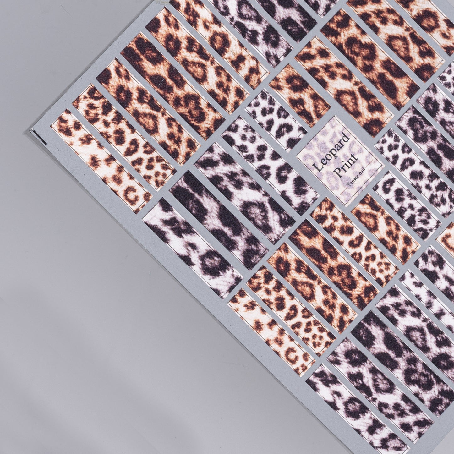 Collection of leopard print pattern nail stickers on a gray background