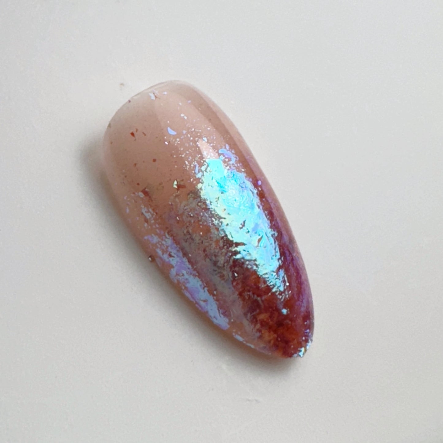 Decorated nail tip on white surface