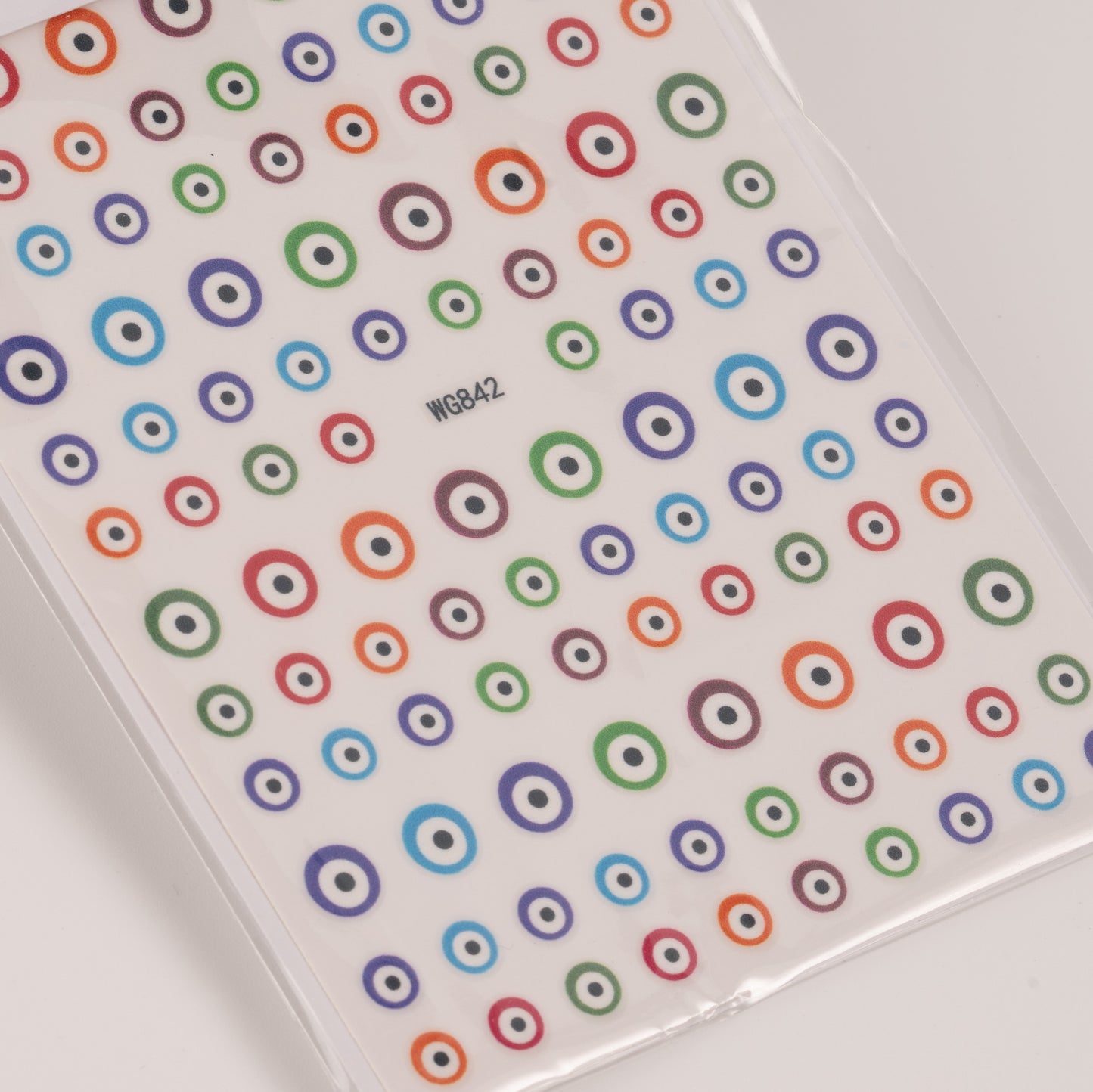 Nail decal sheet with colorful eye design on light background.