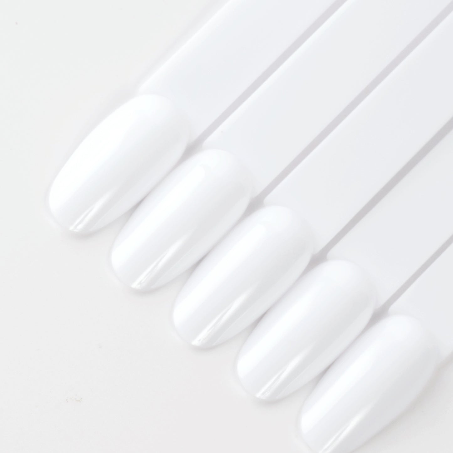 White oval nail swatch sticks on white background.