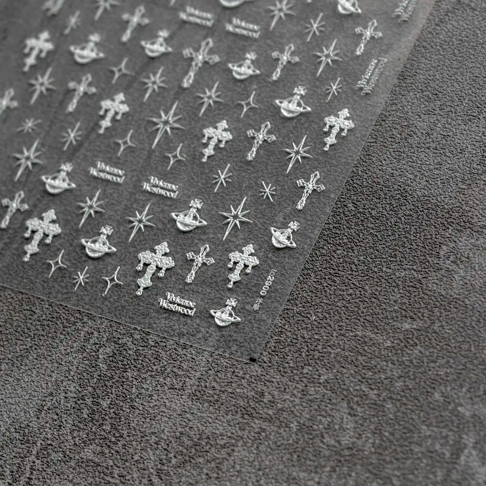 Punk Cross Nail Stickers - Textured Nail Stickers with Extravagant Cross Designs in White, Displayed on a Gray Background."