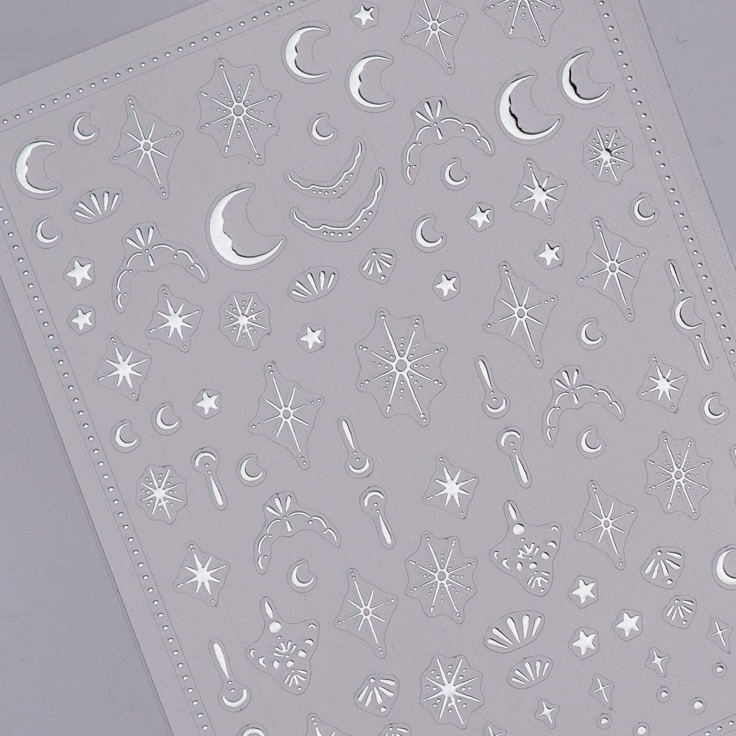 Sheet of star and moon-shaped stickers on a gray background