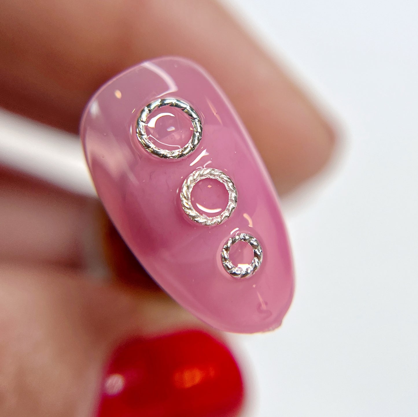 Hand holding decorated nail tip.