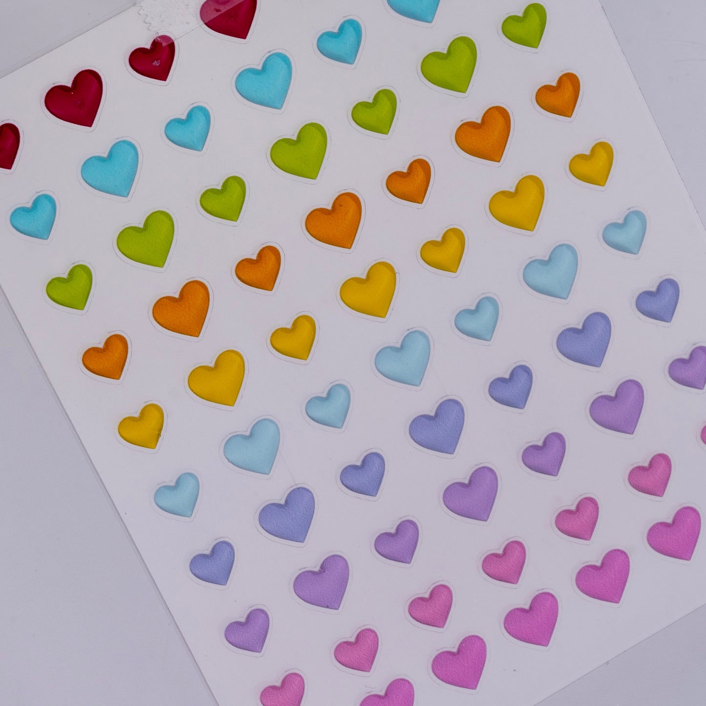 Sheet of colorful heart-shaped stickers on a white background