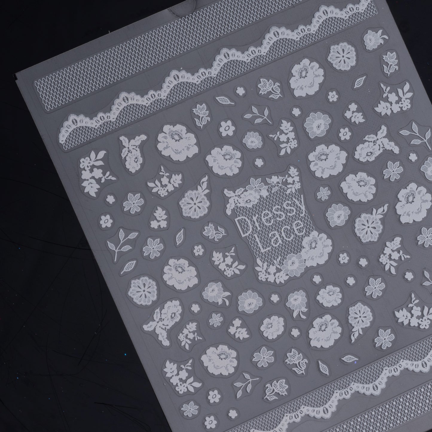 Detail view of nail decal sheet on dark background.