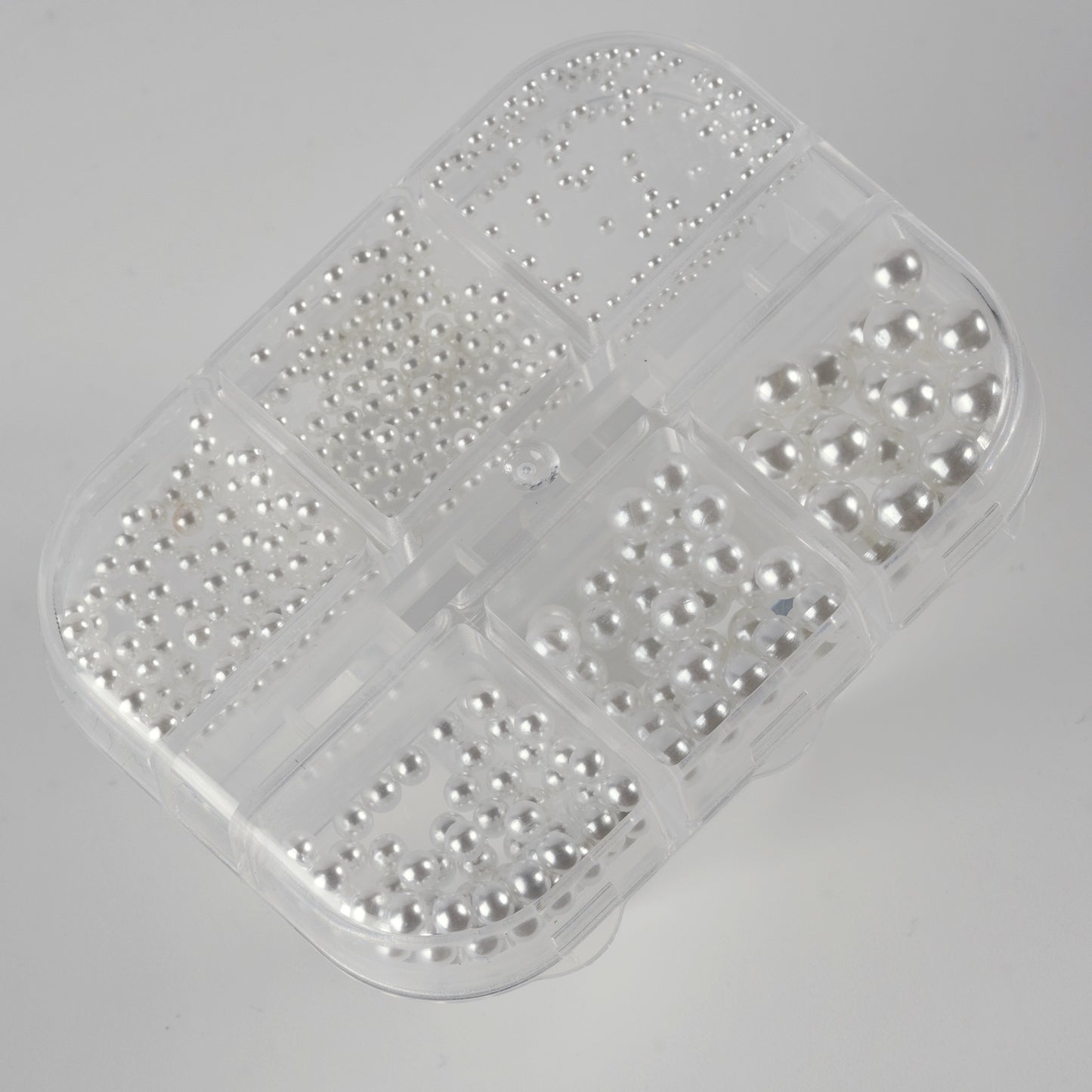 Clear case with white pearls on white background.