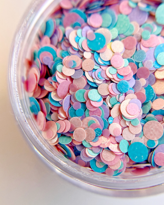 Pastel multi size circle glitter in clear jar on white background.
