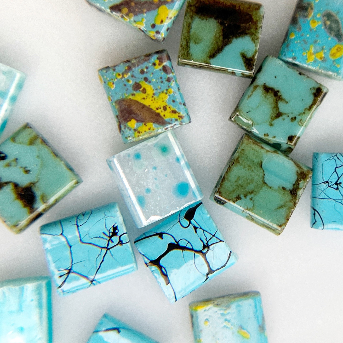 Multicolor square resin nail charms on white background.