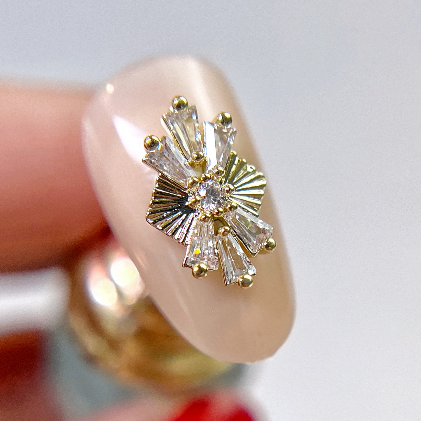 Nail tip with gold rhinestone charm. 