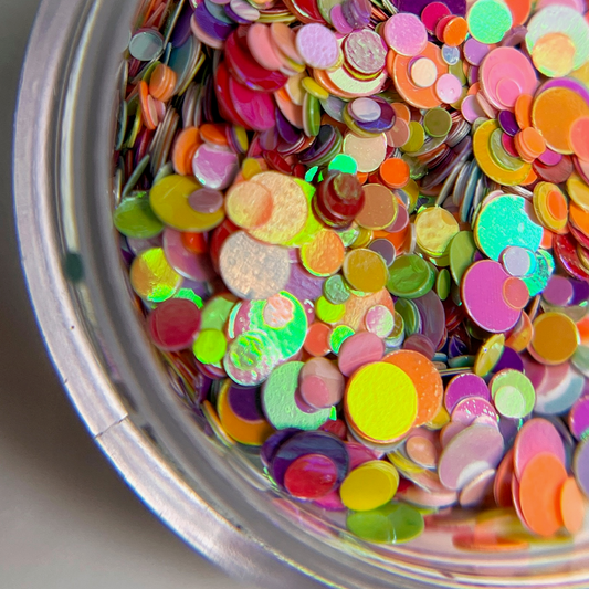 Multicolor dot glitter in clear jar on white background