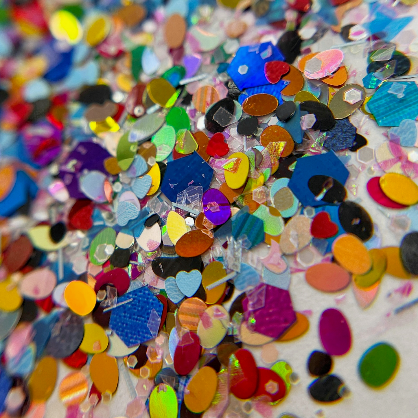 Glitter mix scattered on white background.