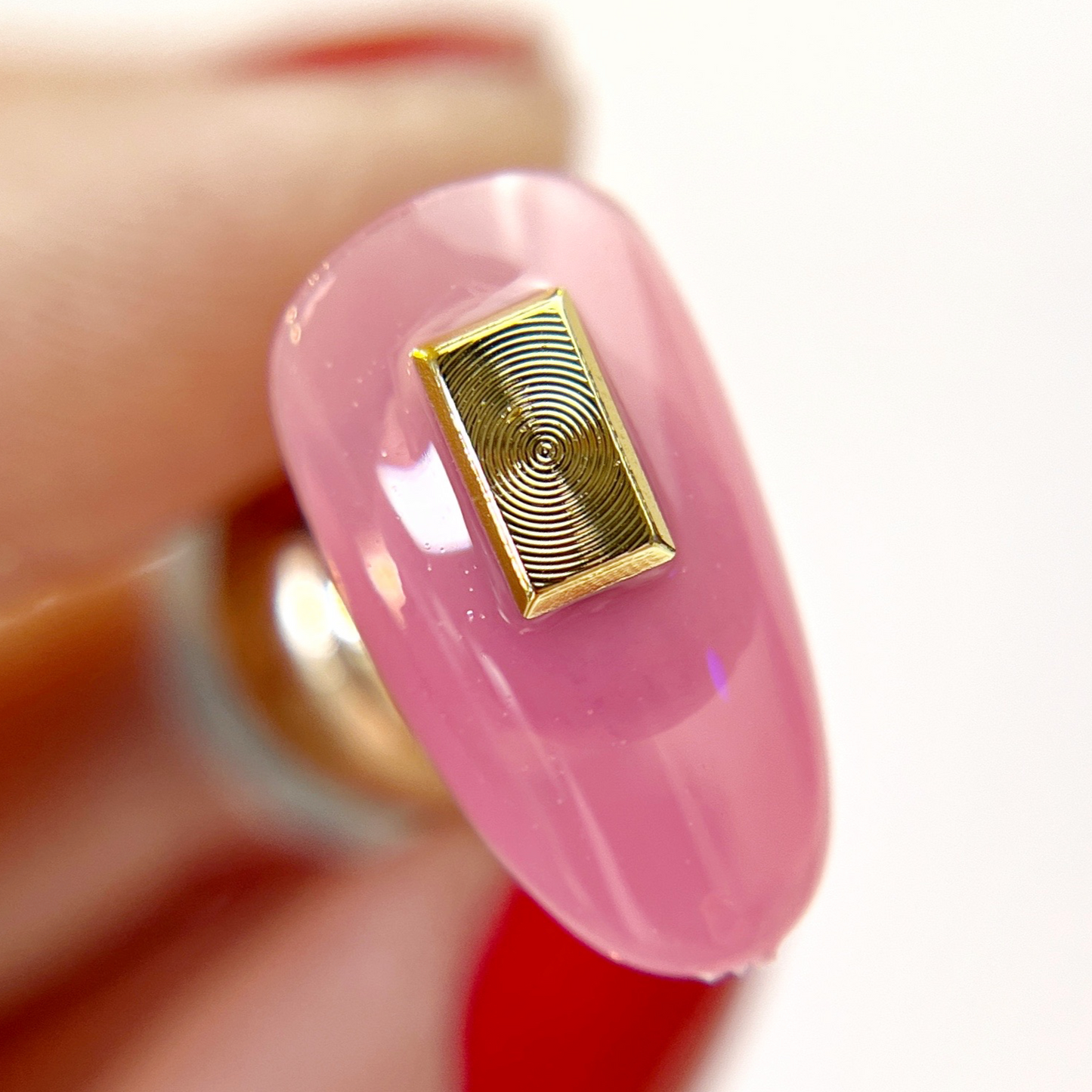 Hand holding decorated nail tip.