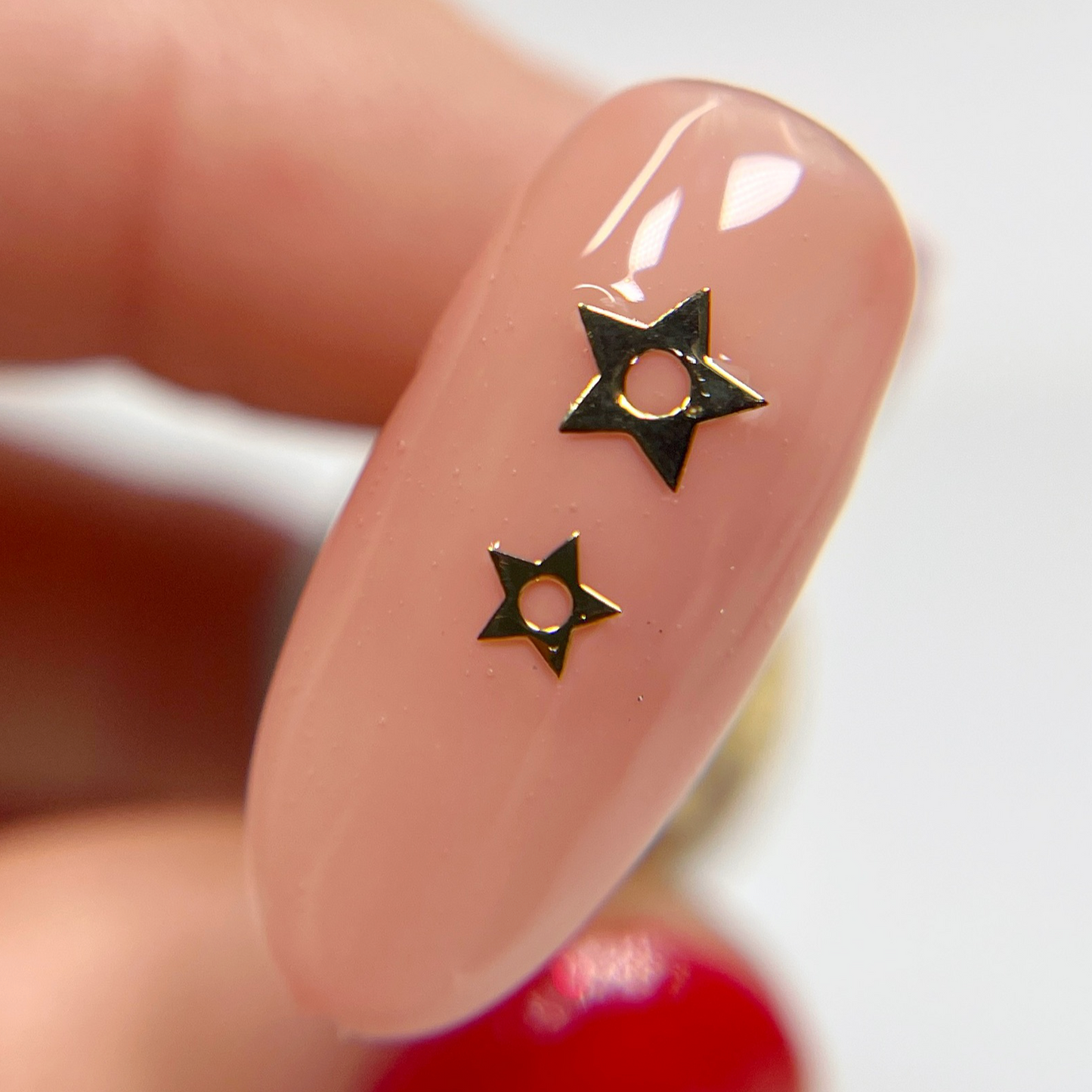 Hand holding decorated nail tip.