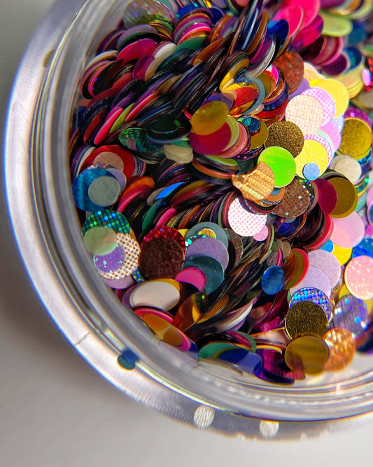Multicolor glitter mix in clear jar on white background.