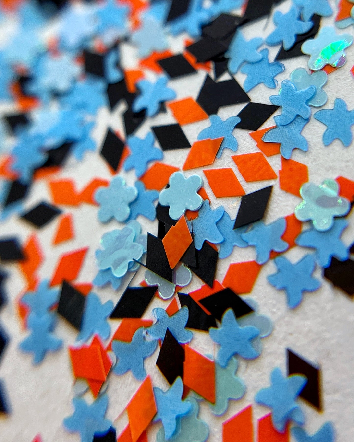 Multicolor nail glitter scattered on white background.