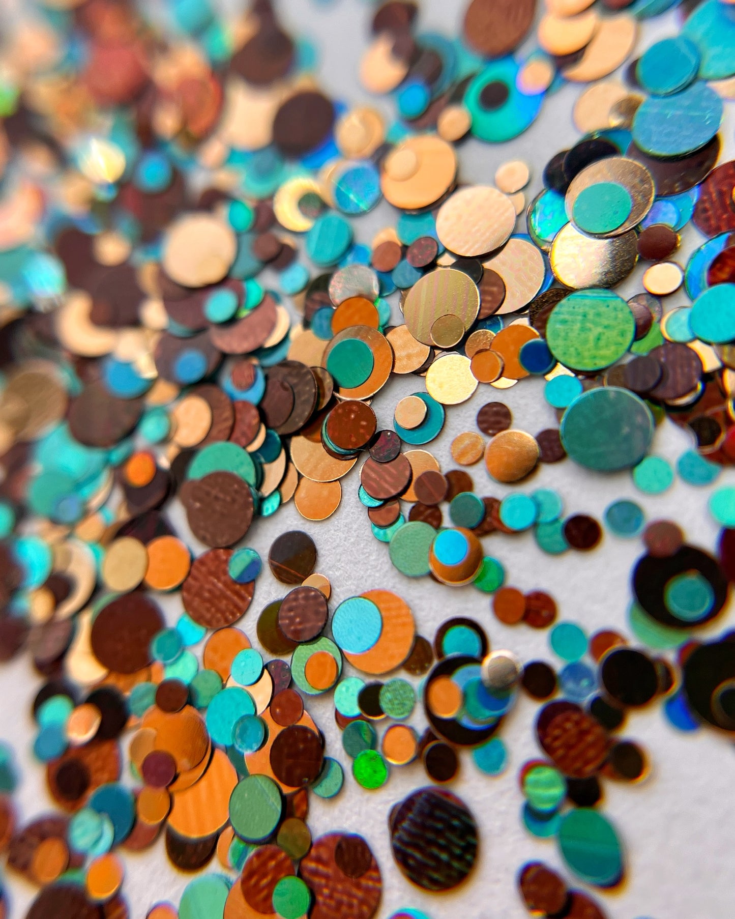Multicolor glitter mix scattered on white bakground.