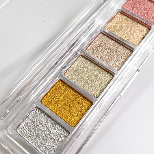 Six color metallic pigment palette in clear container on white background.