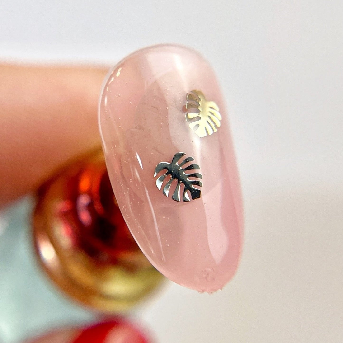 Hand holding decorated nail tip.